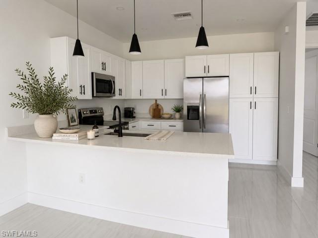 Angle 1- Modern kitchen with quartz countertops, stainless steel appliances, and ample cabinetry.