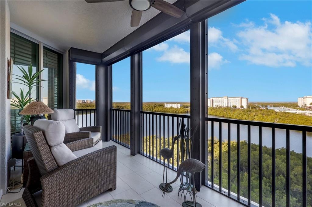 Sunroom featuring a water view, expansive windows, tile patterned flooring, and a textured ceiling