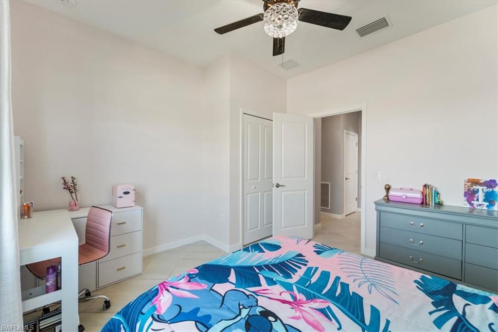 Light-toned walls with a vaulted ceiling and a ceiling fan featuring a decorative light fixture