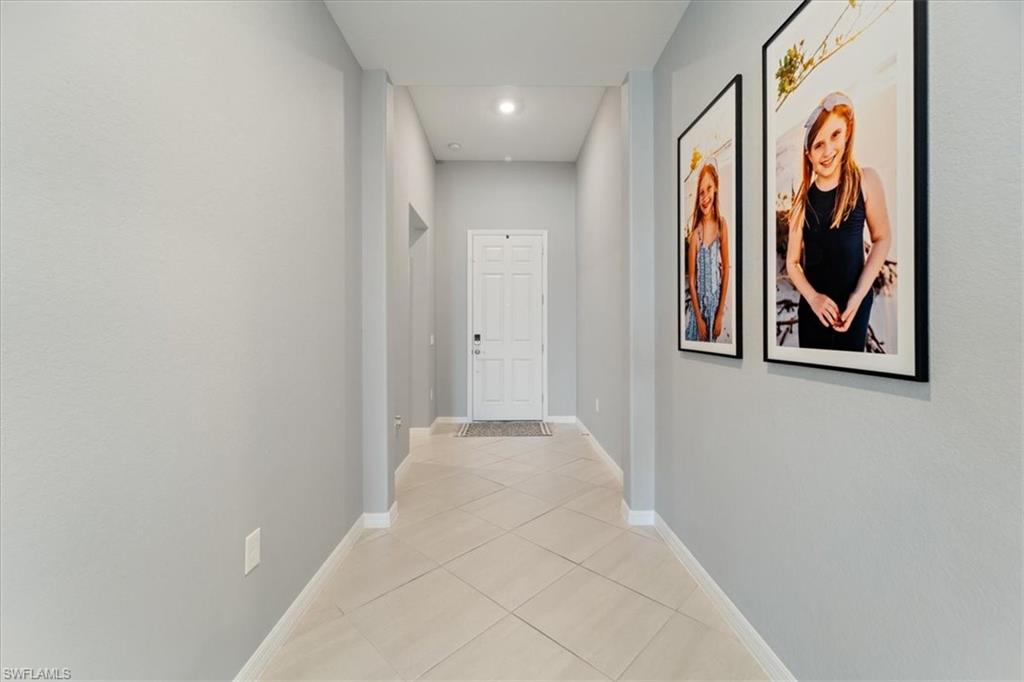 Entryway featuring a white paneled door, recessed lighting, and light-toned diagonal tile flooring