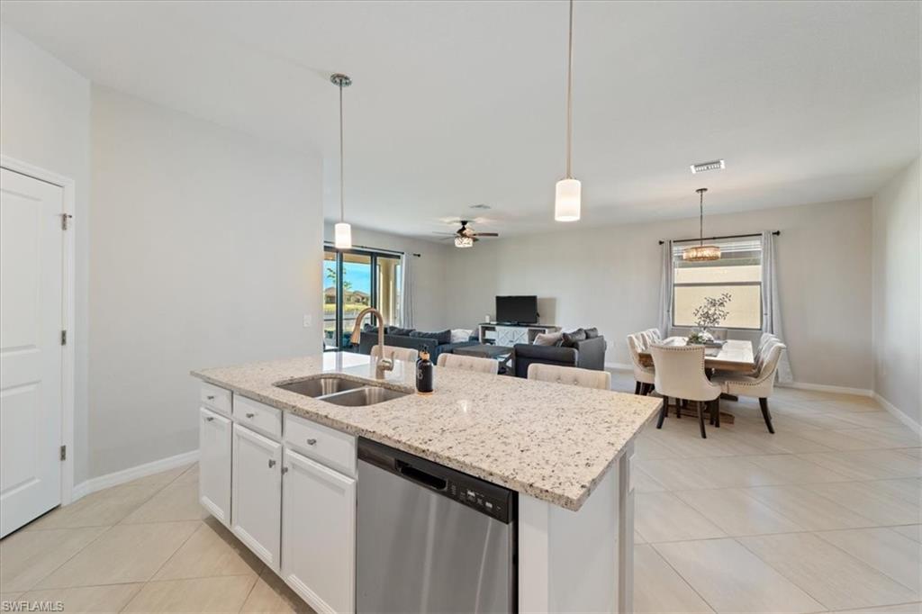 Kitchen island with granite countertop, double stainless steel sink, and integrated dishwasher