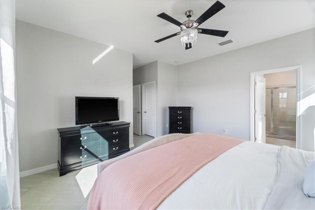 Spacious interior room with light-toned walls and tile flooring