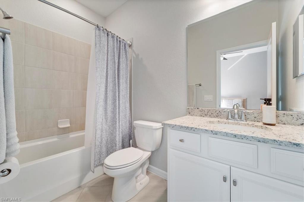 Bathroom featuring a single vanity with stone countertop, undermount sink, and chrome fixtures