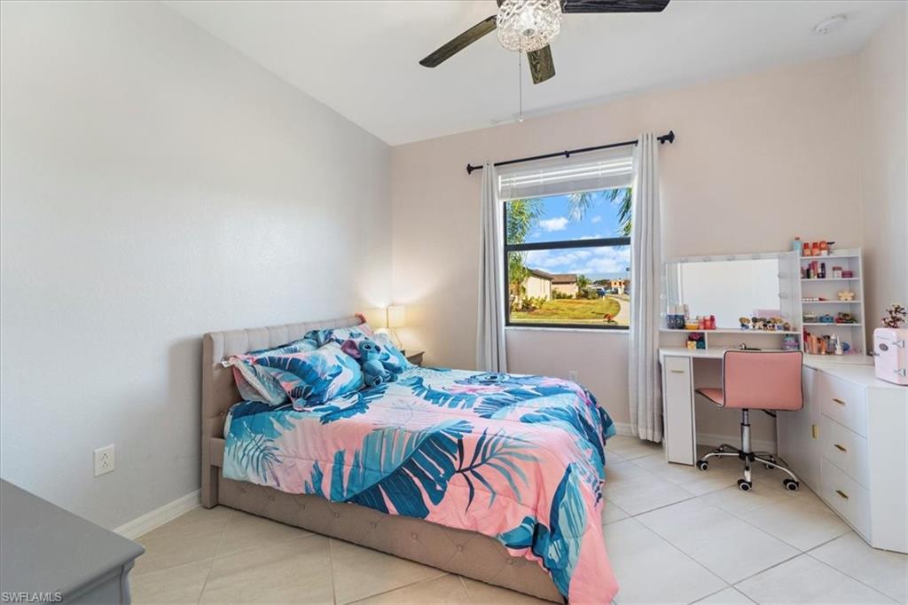 Bedroom featuring a single window with blinds and drapes, a ceiling fan with light fixture, and tile flooring