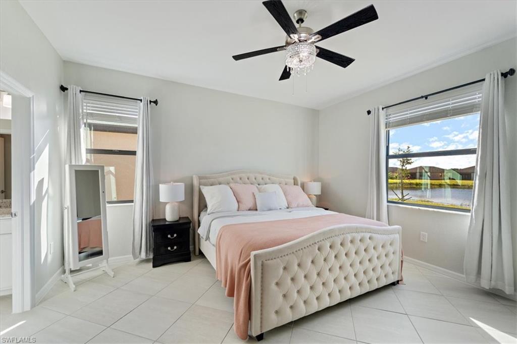 Light-filled interior featuring tile flooring, a decorative ceiling fan, and crown molding