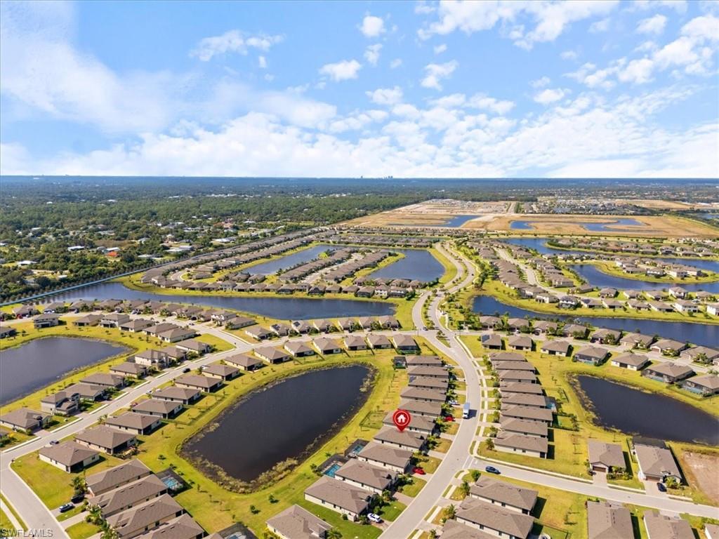 Aerial overview of a residential community featuring numerous single-story homes, multiple waterways, and paved roadways