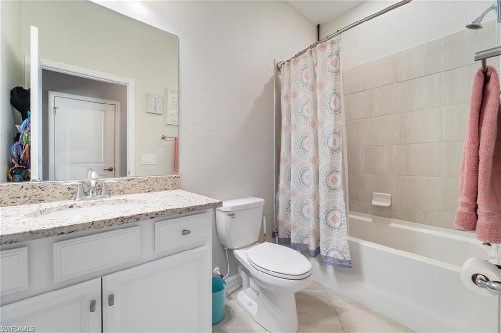 Full bathroom featuring a white vanity with a light-toned speckled countertop, an undermount sink, and a chrome faucet