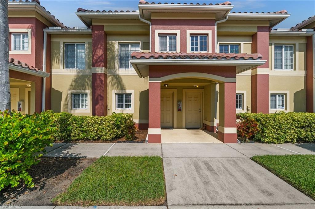 Two-story exterior with a Spanish tile roof, stucco finish, and manicured shrubbery