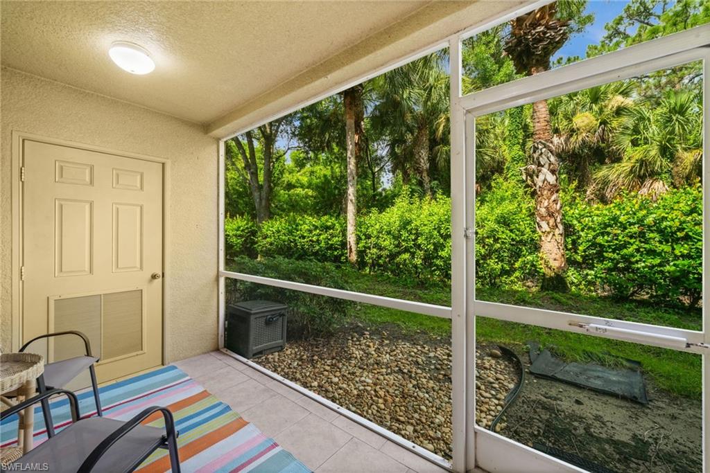 Screened patio featuring tile flooring and a textured wall finish