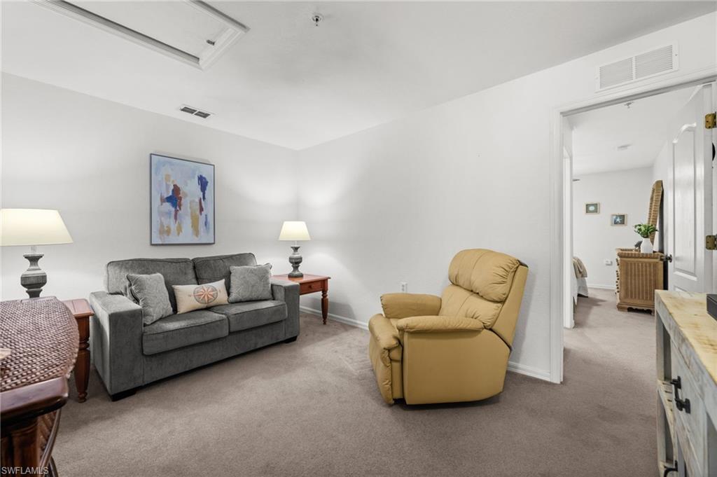 Carpeted room with a doorway opening to another interior space