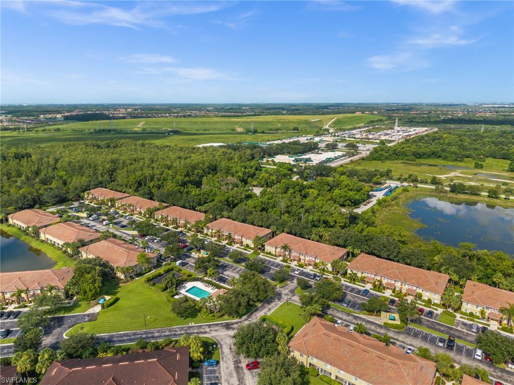 Aerial perspective showcasing multiple residential buildings with terracotta-style tile roofs, surrounded by lush green landscaping