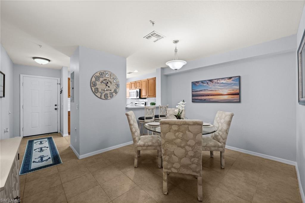 Dining area featuring tile flooring, a contemporary chandelier, and a neutral color palette