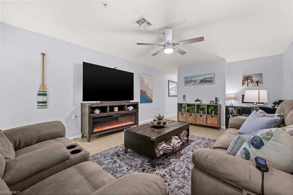 Open concept living area featuring light-colored walls and tile flooring