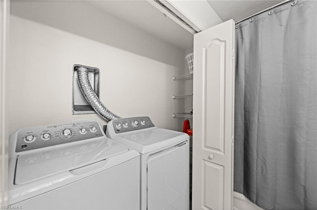 Dedicated laundry area featuring a white washing machine and dryer, a dryer vent, and a bi-fold door