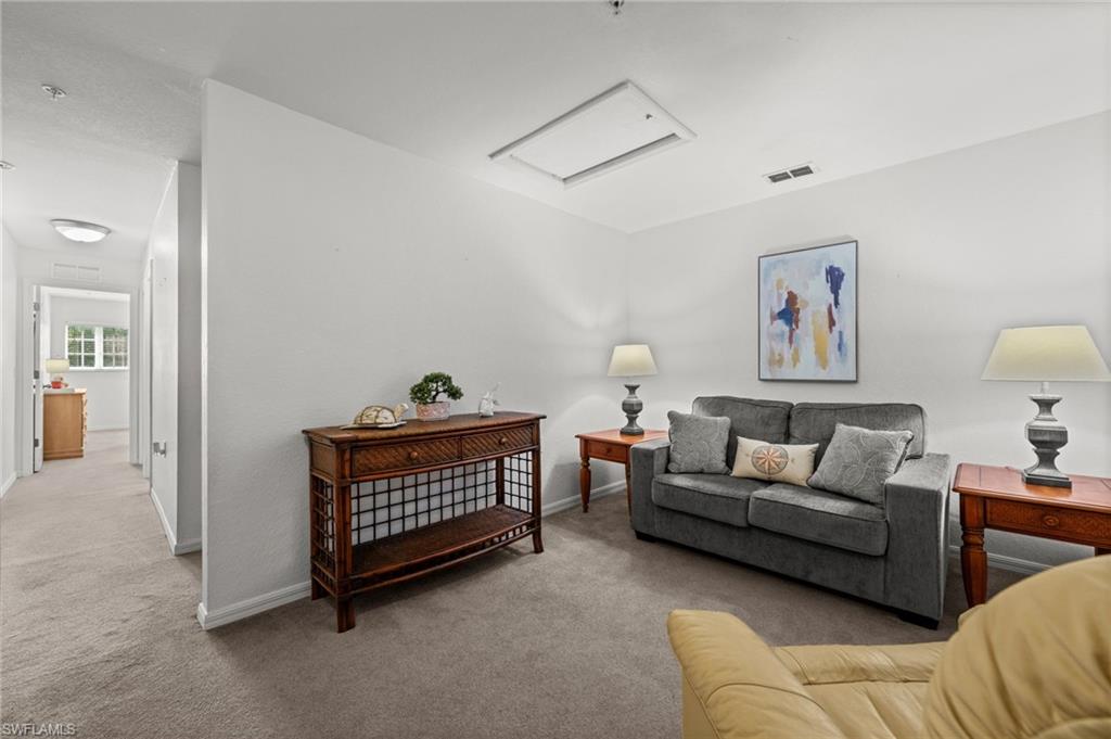 Interior room featuring light-colored walls and soft carpet flooring