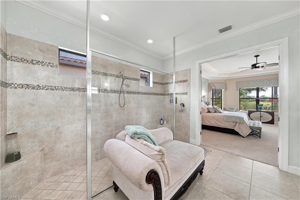 Walk-in shower with full-height tile surround, mosaic accent bands, and glass enclosure