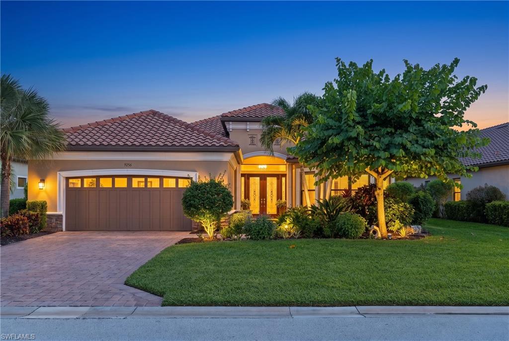 Mediterranean-style exterior featuring a tile roof, stucco finish, and stone accents