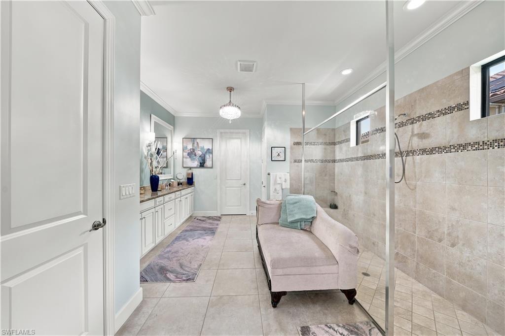 Spacious bathroom featuring an expansive glass-enclosed shower with tile surround and decorative mosaic accents