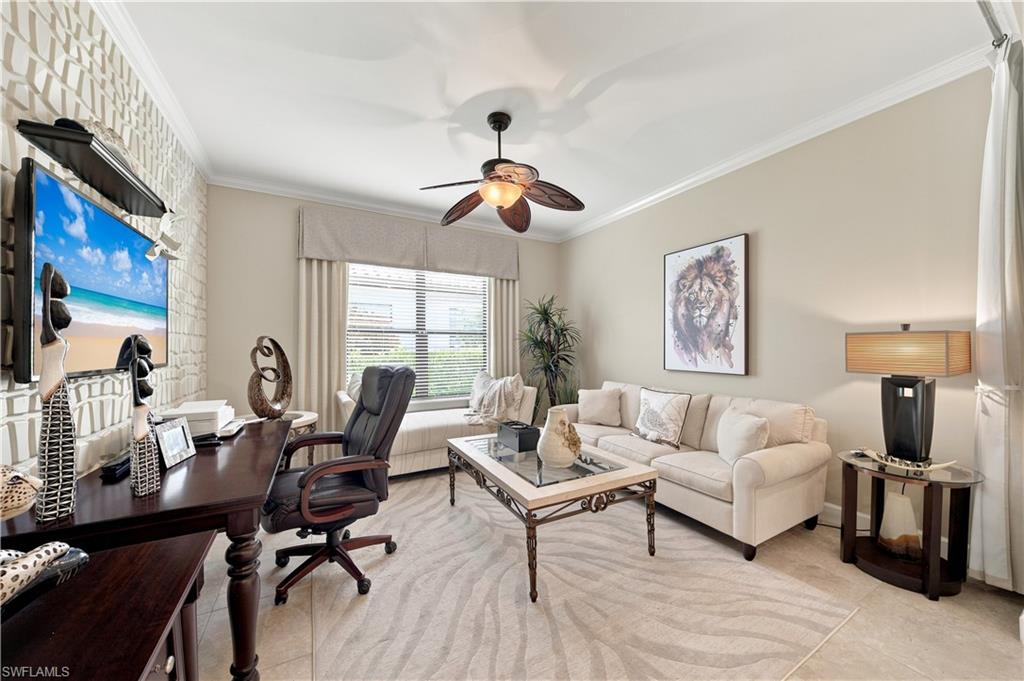 Spacious interior featuring a decorative accent wall, crown molding, and a ceiling fan with light fixture