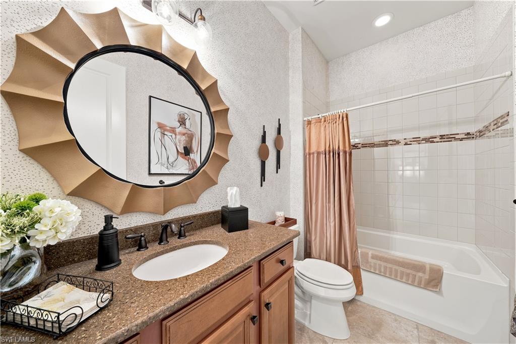 Bathroom featuring a vanity with a dark speckled countertop and an undermount sink