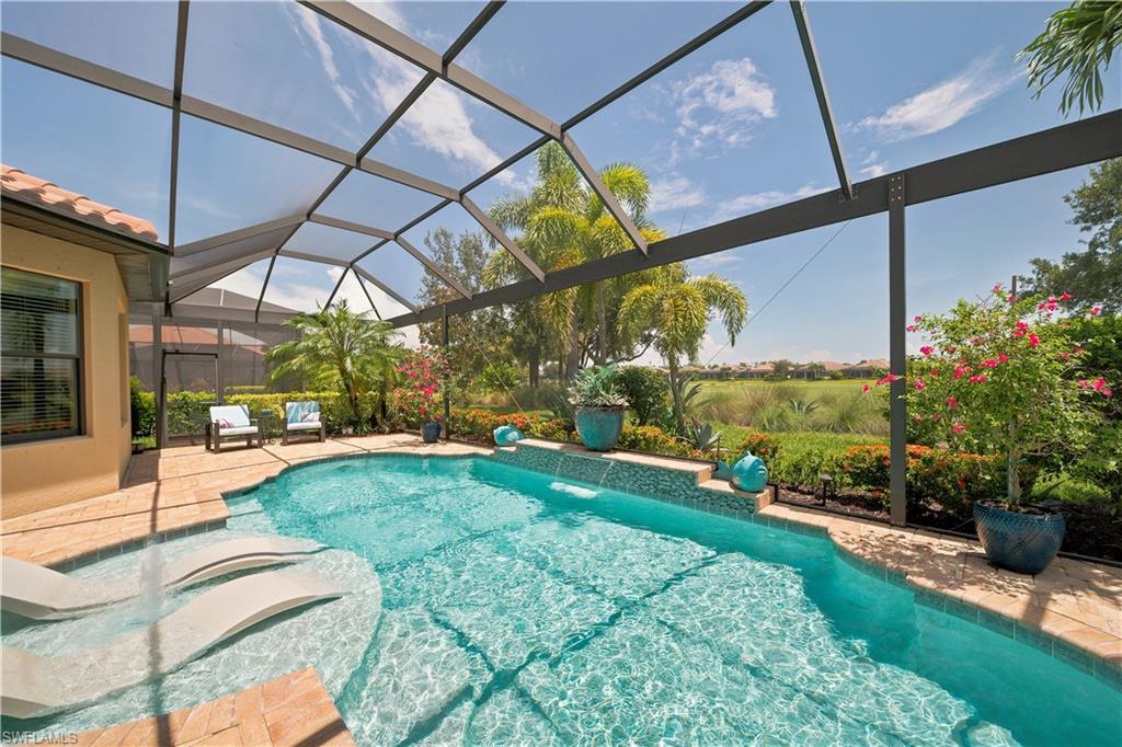 Screen-enclosed pool area featuring a freeform pool with integrated sun shelf