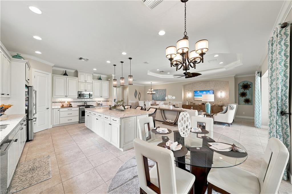 Spacious open-concept living area featuring a gourmet kitchen with white shaker cabinetry, granite countertops, and stainless steel appliances