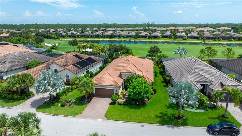 Mediterranean-style residence featuring a tile roof, an attached garage, and a paver driveway