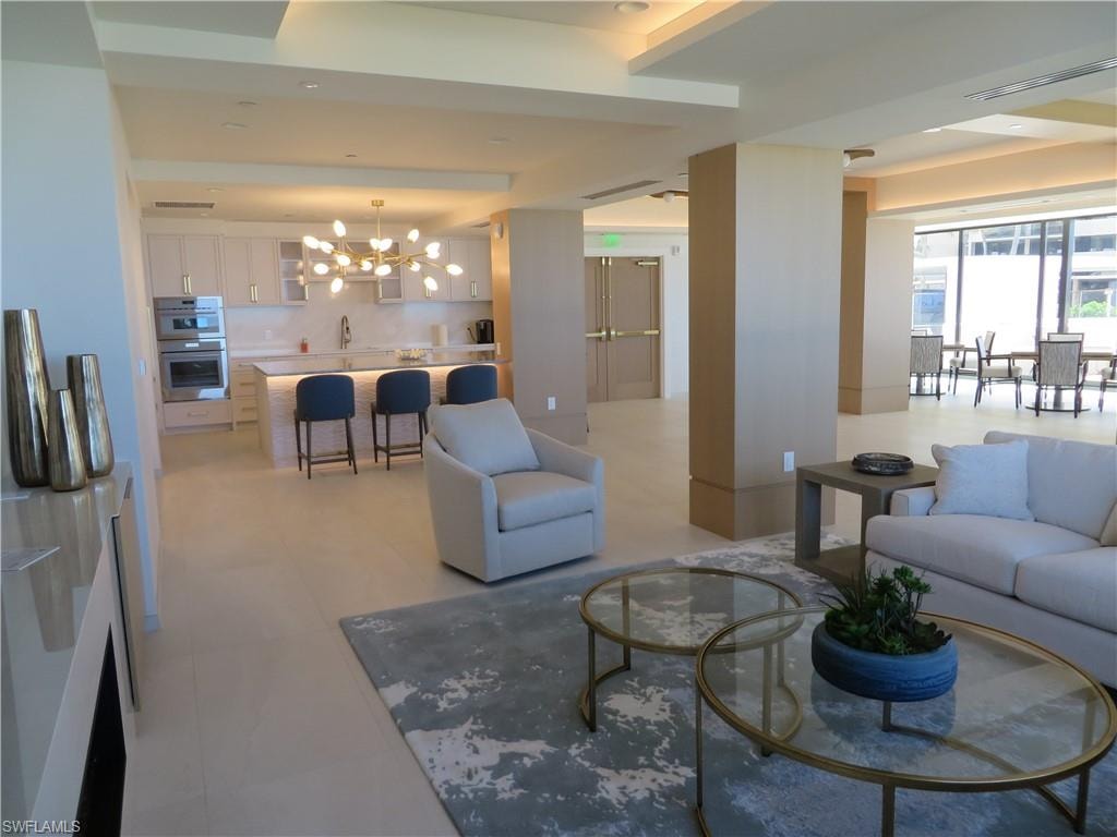 Spacious Social Room featuring a chandelier and large screen televisions.
