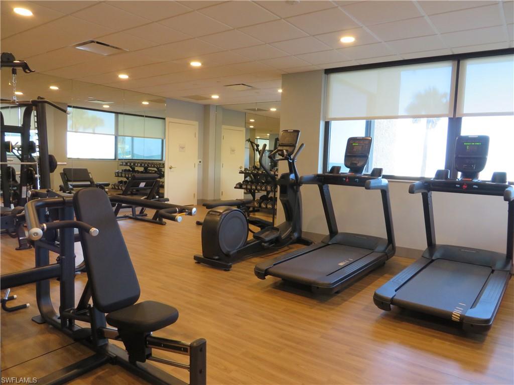 Workout area with wood finished floors and a drop ceiling