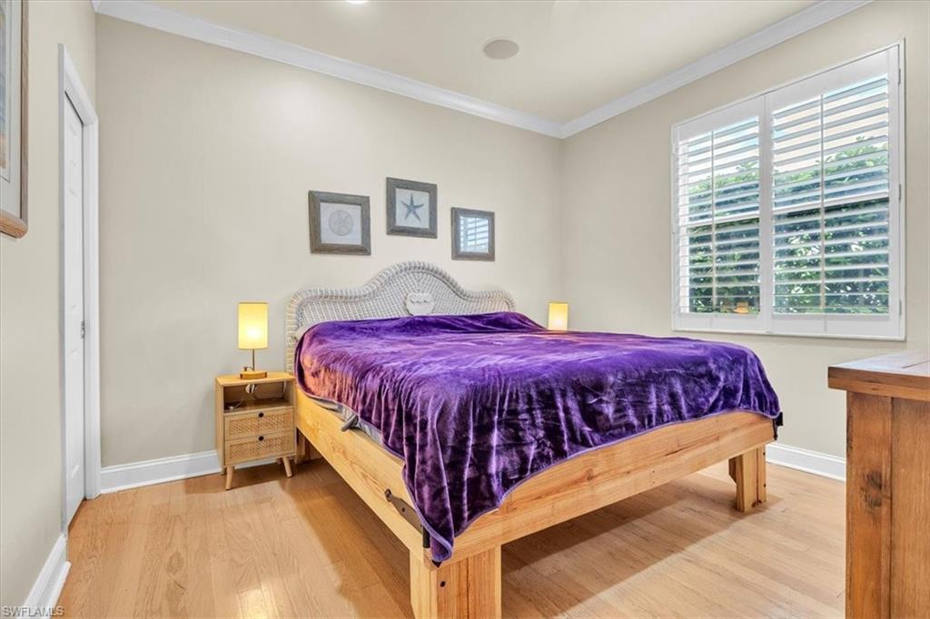 Room featuring light wood-finish flooring, white crown molding, and recessed lighting