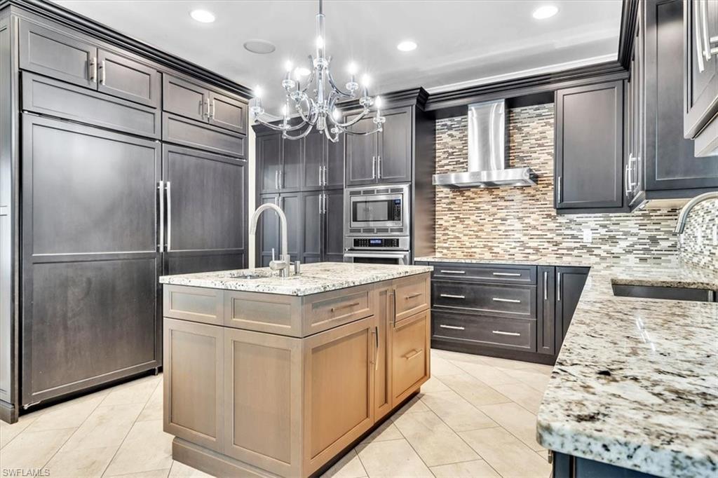 Kitchen featuring dark wood-finish cabinetry, granite countertops, and a tiled backsplash