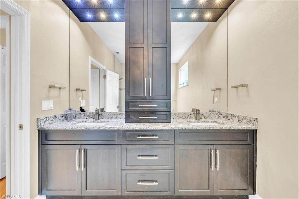 Dual vanity with dark wood-finish cabinetry and silver-toned hardware
