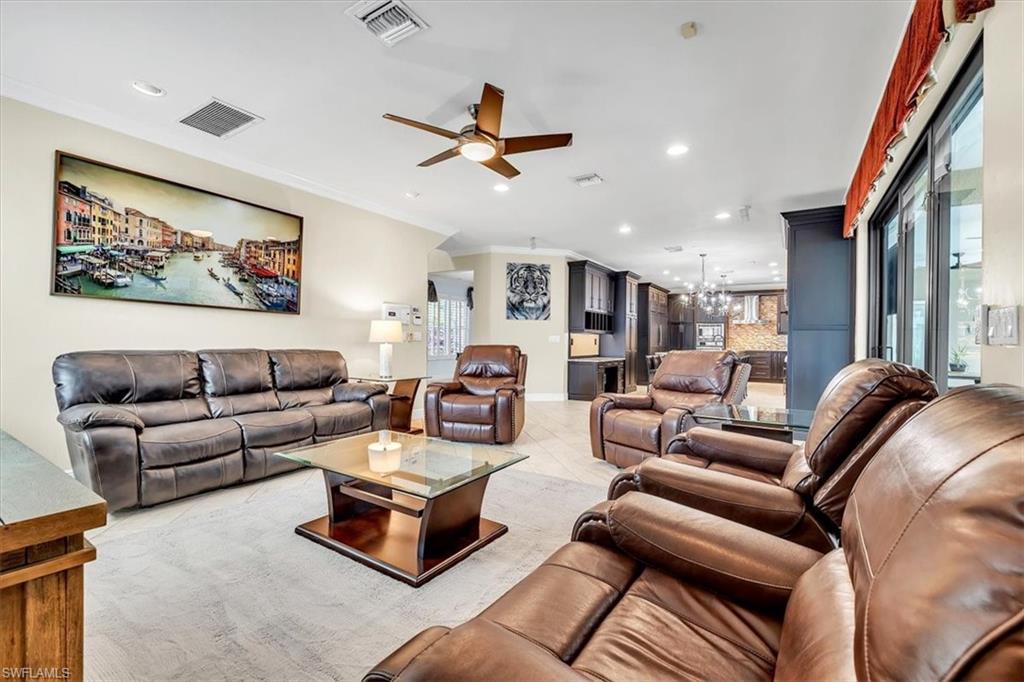Spacious living area featuring light-toned flooring and recessed lighting