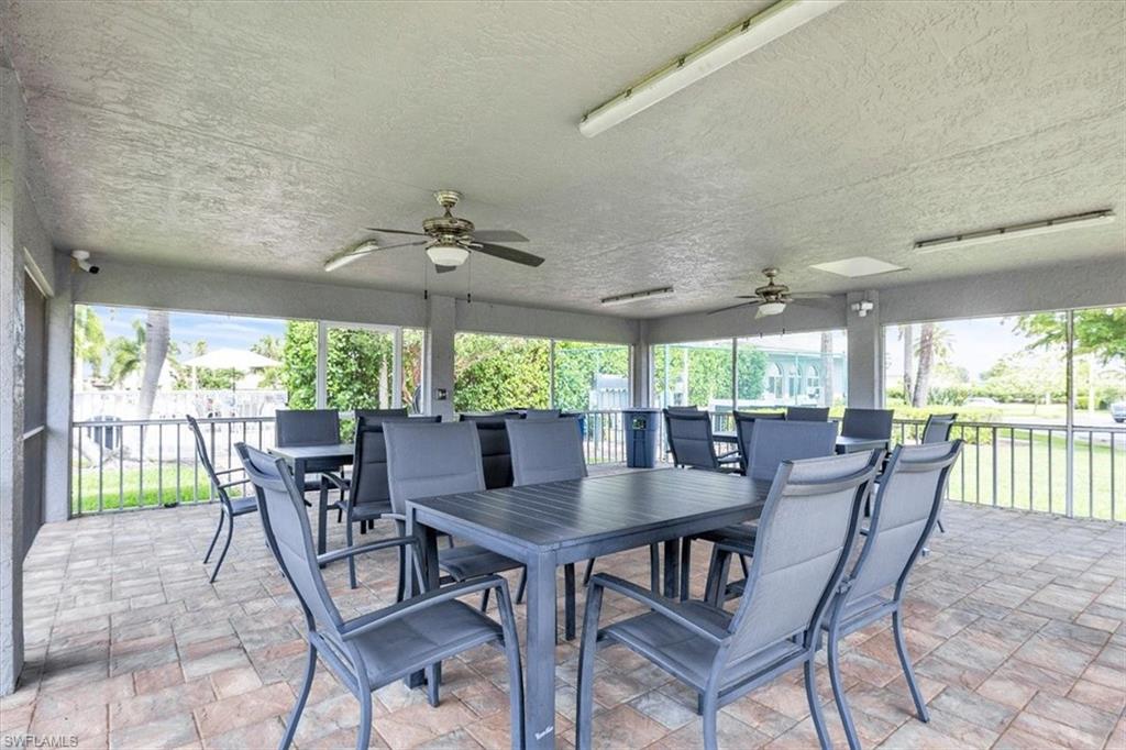 Screened patio area featuring a textured ceiling with two ceiling fans, recessed lighting, and brick-patterned pavers