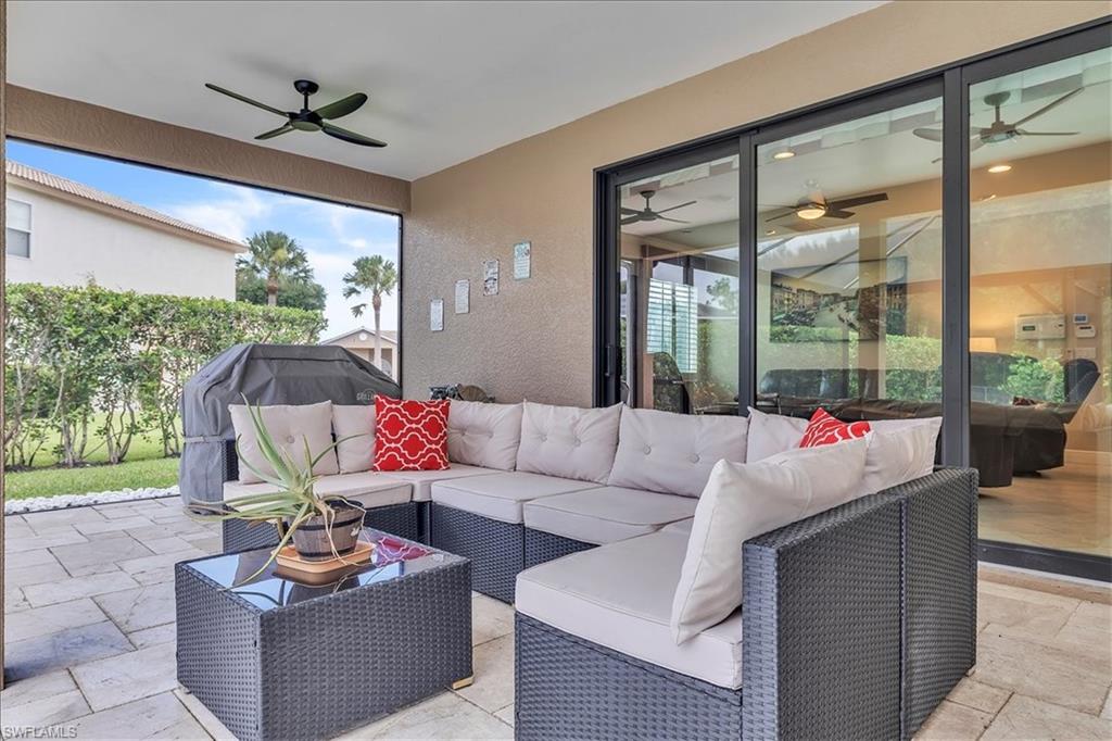 Screened patio featuring a ceiling fan, sliding glass doors, and light-toned paver flooring
