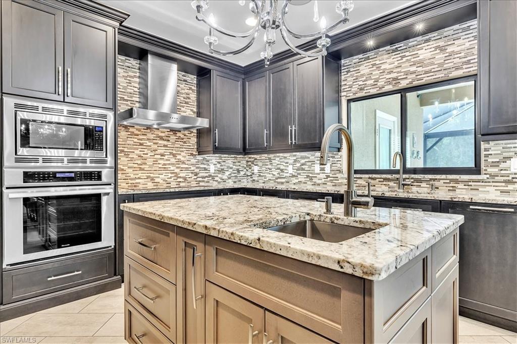 Kitchen featuring a central island with an undermount sink and granite countertop