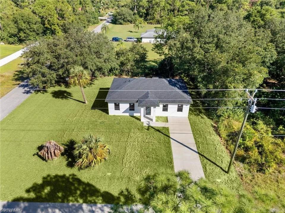 Freshly painted white exterior with a dark shingle roof and a concrete driveway