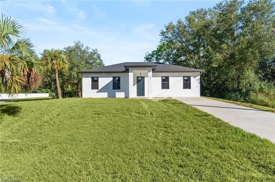 Contemporary single-story residence featuring a white stucco exterior and dark trim accents