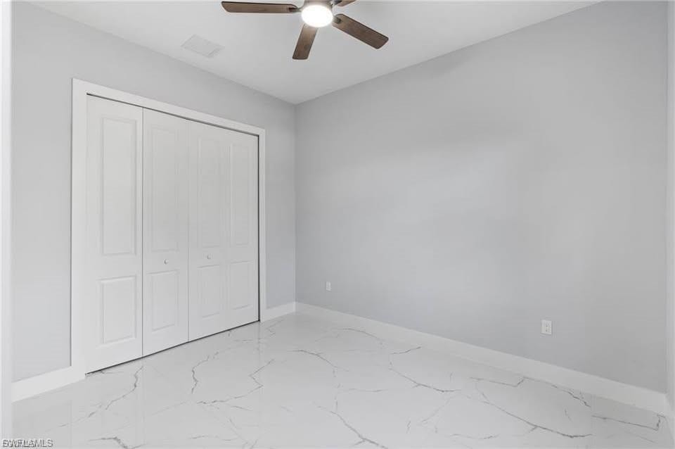 Room featuring wood-finish ceiling fan, light gray wall paint, and white baseboards