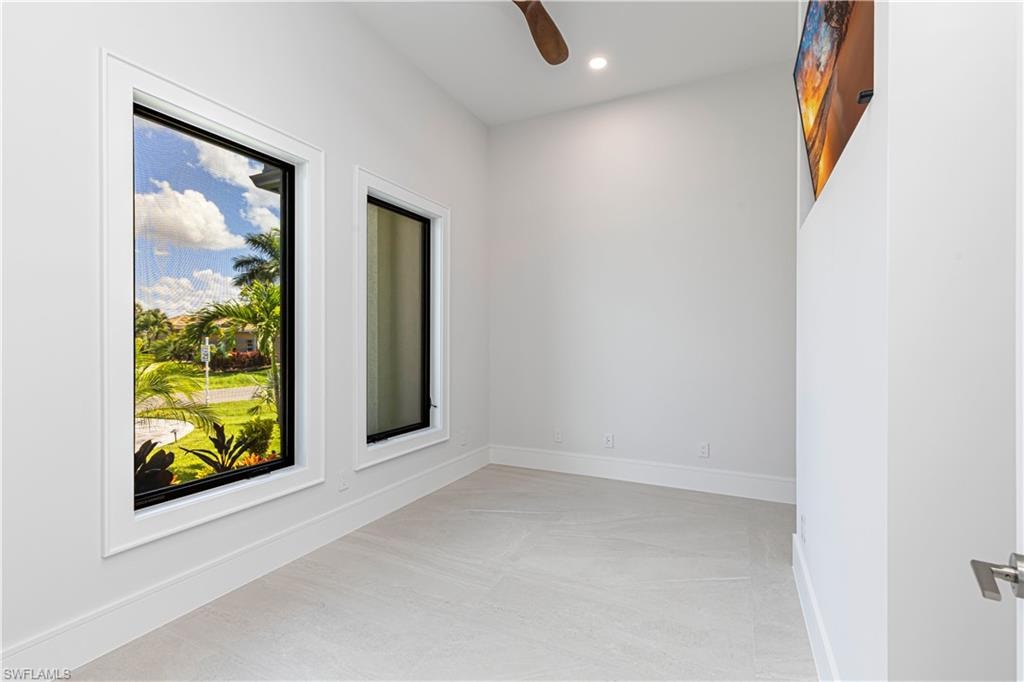 Bright interior space featuring light-toned flooring, white walls, and a ceiling fan