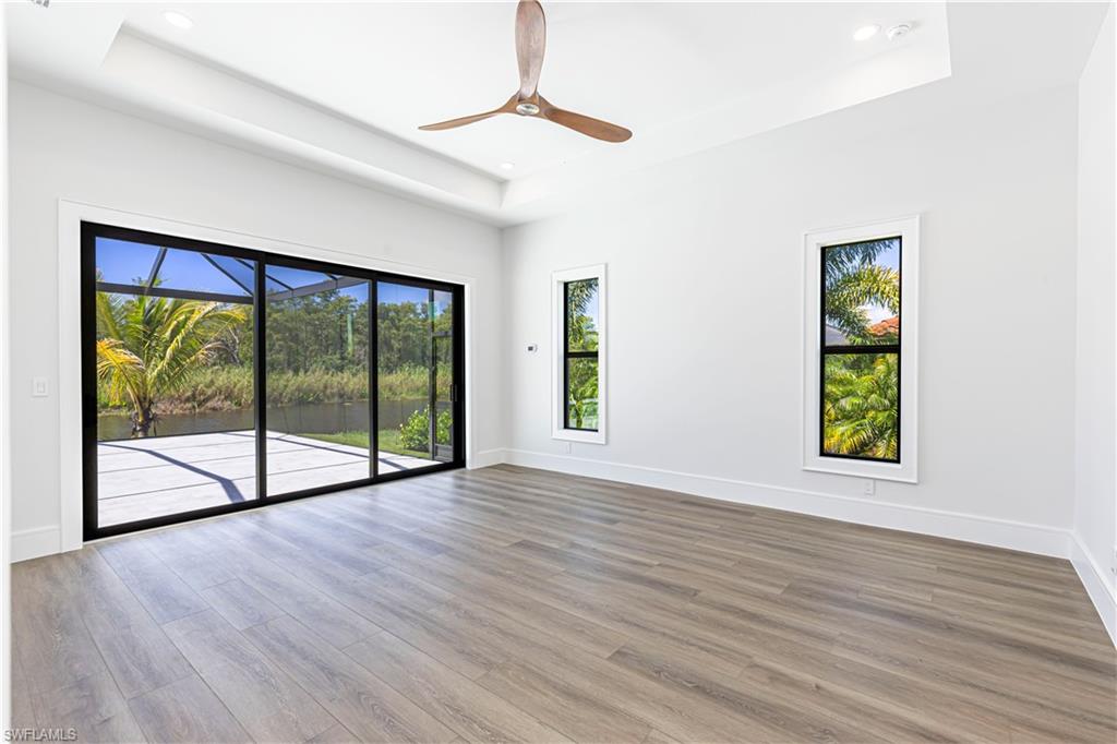 Spacious room with wood-finish flooring and a tray ceiling