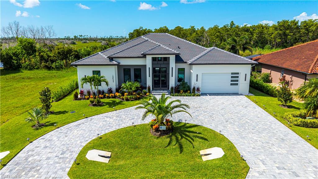 Contemporary single-story residence featuring a gray tile roof and a paver driveway
