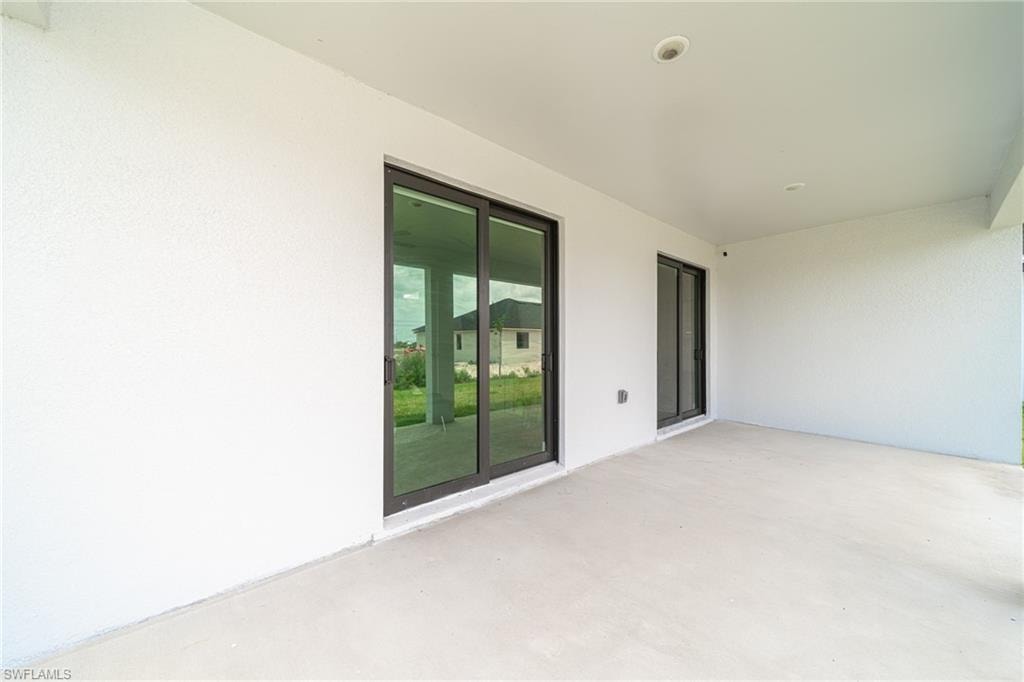 Covered patio featuring a concrete slab and white stucco walls