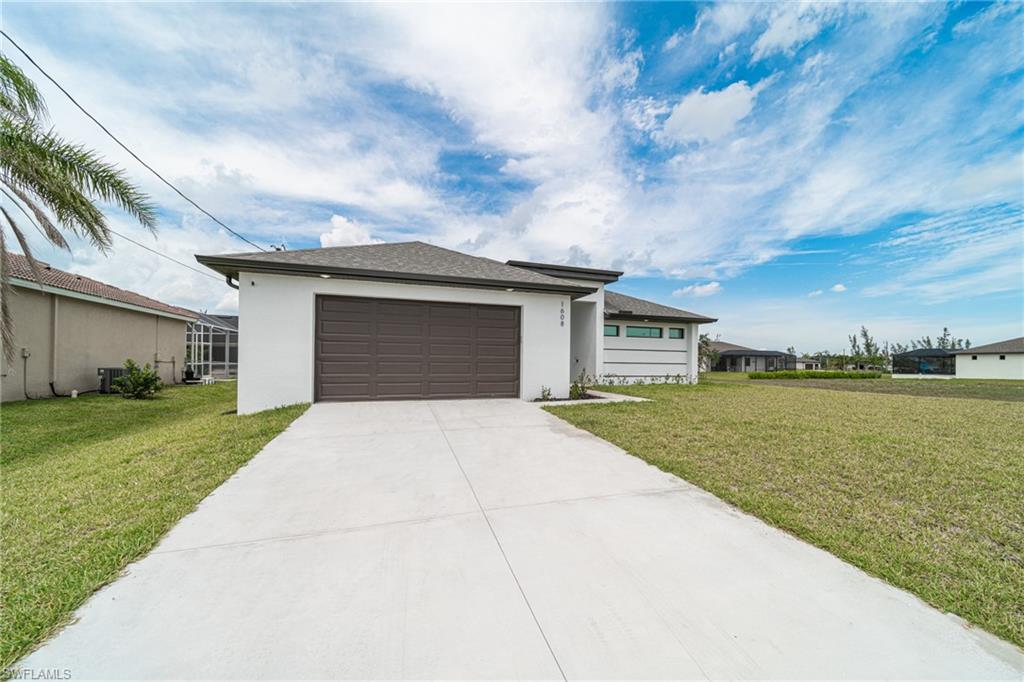 Contemporary single-story residence featuring a white stucco exterior and a dark brown garage door