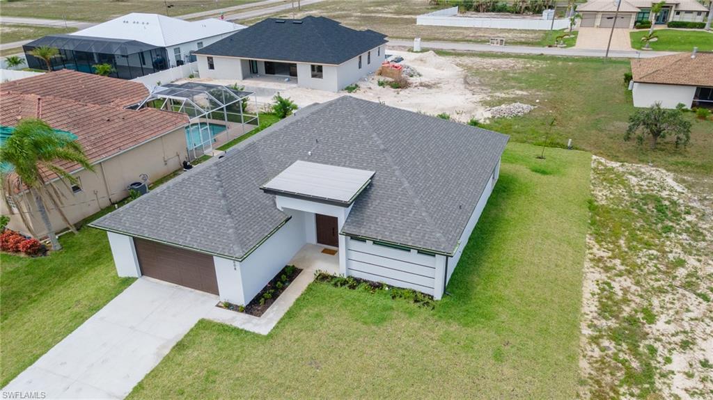 Contemporary single-story residence featuring a gray shingle roof, white exterior siding, and a brown garage door