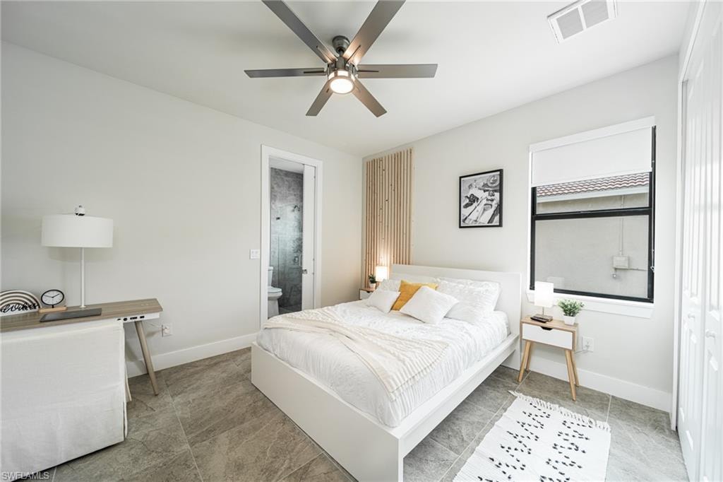 Spacious bedroom featuring tile flooring, a contemporary ceiling fan, and a light wood-finish accent wall behind the bed