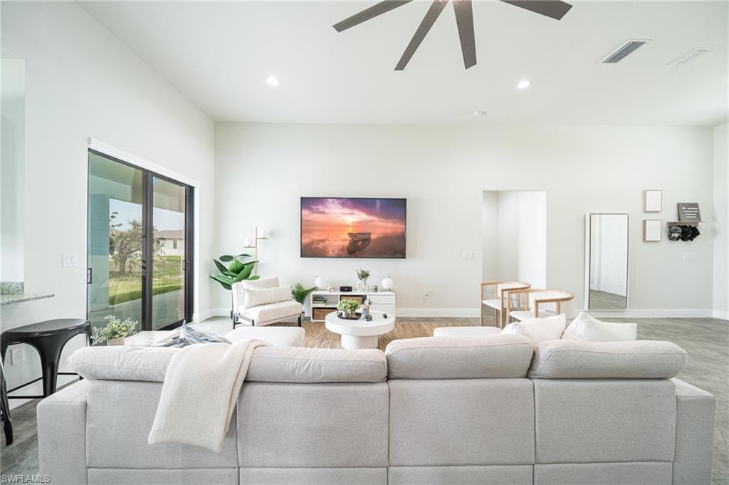 Spacious living area featuring high ceilings, recessed lighting, and wood-finish flooring