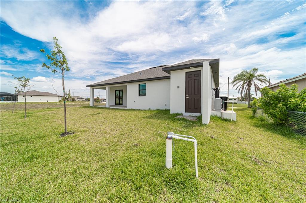Spacious backyard with a covered patio, double glass doors, and a detached utility structure