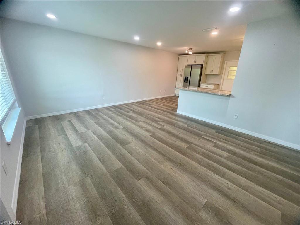Spacious interior featuring wood-finish flooring, recessed lighting, and a window with blinds