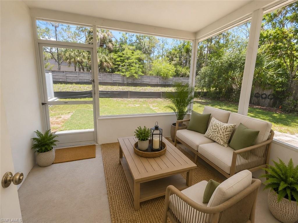 Screened porch featuring a slatted wood-finish coffee table and a neutral rug